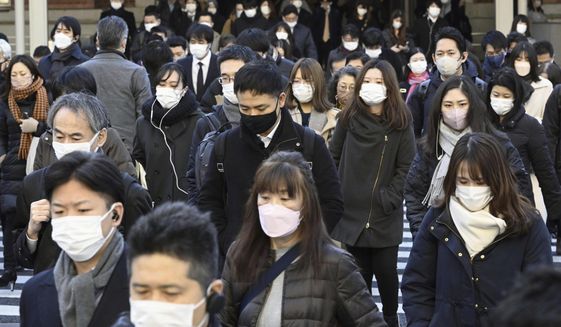Commuters wear masks outside Tokyo Station in Tokyo Friday, Jan. 20, 2023. Japan&#x27;s Prime Minister Fumio Kishida on Friday announced plans to start preparations for downgrading legal status of COVID-19 to an equivalent of seasonal influenza in the spring, a move that would further relax mask wearing and other preventive measures as the country seeks an exit plan. (Kyodo News via AP)