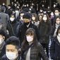 Commuters wear masks outside Tokyo Station in Tokyo Friday, Jan. 20, 2023. Japan&#39;s Prime Minister Fumio Kishida on Friday announced plans to start preparations for downgrading legal status of COVID-19 to an equivalent of seasonal influenza in the spring, a move that would further relax mask wearing and other preventive measures as the country seeks an exit plan. (Kyodo News via AP)