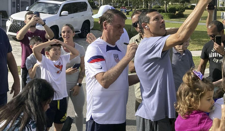 Former Brazil President Jair Bolsonaro, center, meets with supporters outside a vacation home where he is staying near Orlando, Fla., on Wednesday, Jan. 4, 2023. The capital uprising by Bolsonaro&#x27;s supporters on Jan. 8, 2023 failed to overthrow Brazilian democracy and Bolsonaro flew to Florida, but millions of people in Brazil believe so strongly in Brazilian-style social conservatism that the movement will persist without its namesake, according to academics who study the Bolsonarita movement and members of the movement themselves. (Skyler Swisher/Orlando Sentinel via AP, File)