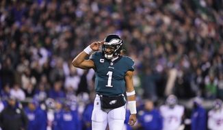 Philadelphia Eagles quarterback Jalen Hurts reacts after throwing a touchdown pass to wide receiver DeVonta Smith during the first half of an NFL divisional round playoff football game against the New York Giants, Saturday, Jan. 21, 2023, in Philadelphia. (AP Photo/Matt Slocum)