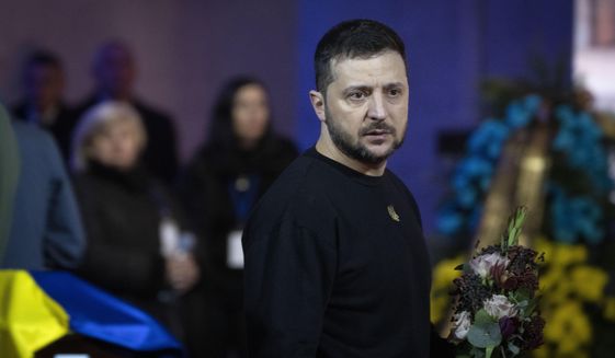 Ukrainian President Volodymyr Zelenskyy pays his respects to victims of a deadly helicopter crash during a farewell ceremony in Kyiv, Ukraine, Saturday, Jan. 21, 2023. Interior Minister Denys Monastyrsky, his Deputy Yevhen Yenin, State Secretary Yurii Lubkovych, national police official and the three crew members were killed in a helicopter crash on Wednesday in Kyiv suburbs of Brovary. (AP Photo/Efrem Lukatsky)