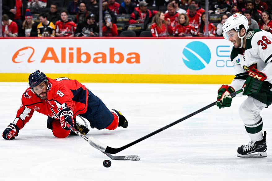 Washington Capitals left wing Alex Ovechkin (8) tries to poke the puck away while down on the ice against the Minnesota Wild at Capital One Arena, Washington, D.C., January 17, 2023. (Photo by Brian Murphy)