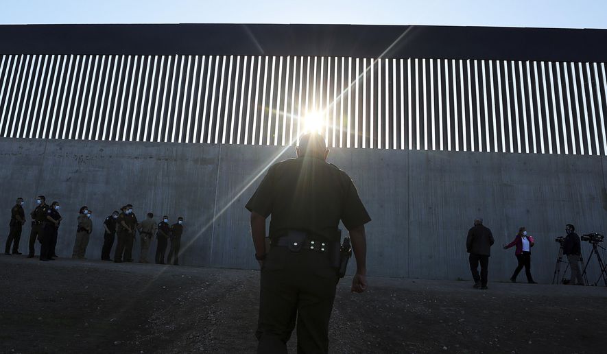In this Oct. 29, 2020 file photo, a U.S. Border Patrol agent walks up to a new section of the border wall before the arrival of Acting Homeland Secretary Chad Wolf Thursday in McAllen, Texas. (Joel Martinez/The Monitor via AP)