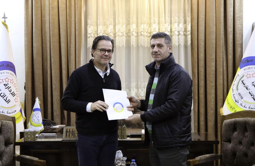 In this photo provided by Autonomous Administration of North and East Syria, Stéphane Romatet, head of the crisis management and support center in the French Foreign Ministry, left, poses for a photo with Robel Baho, deputy head of the External Relations Department of the Autonomous Administration of North and East Syria, after signing a document of surrender for women and children of Islamic State group militants, at the department&#x27;s headquarters in the city of Qamishli, Syria, Monday, Jan. 23, 2023. France has repatriated another group of women and children from former Islamic State group-controlled areas of Syria. (Autonomous Administration of North and East Syria via AP)