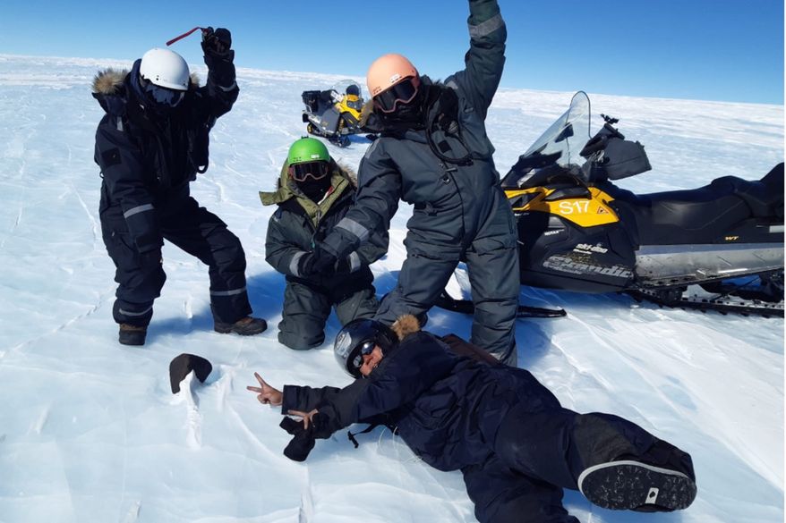 Researchers Maria Schönbächler (wearing a white helmet), Maria Valdes (green helmet), Vinciane Debaille (orange helmet) and Ryoga Maeda (black helmet) pose with a 16.7-pound meteorite in Antarctica. (Photo courtesy of Maria Valdes)