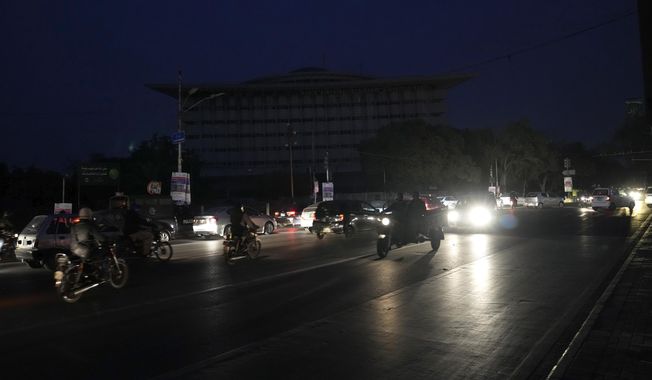 Motorcyclists and cars drive on a road during a national-wide power breakdown, in Lahore, Pakistan, Monday, Jan. 23, 2023. Much of Pakistan was left without power Monday as an energy-saving measure by the government backfired. The outage spread panic and raised questions about the cash-strapped government&#x27;s handling of the country&#x27;s economic crisis. (AP Photo/K.M. Chaudary)