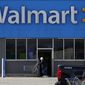 A woman pushes a shopping cart at a Walmart in Rolling Meadows, Ill. The company said in a memo Tuesday, Jan. 24, 2023, that U.S. workers will get pay raises next month, increasing starting wages to between $14 and $19 an hour. (AP Photo/Nam Y. Huh) **FILE**