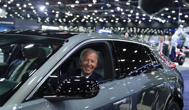 President Joe Biden drives a Cadillac Lyriq through the showroom during a tour at the Detroit Auto Show, Sept. 14, 2022, in Detroit. (AP Photo/Evan Vucci, File)