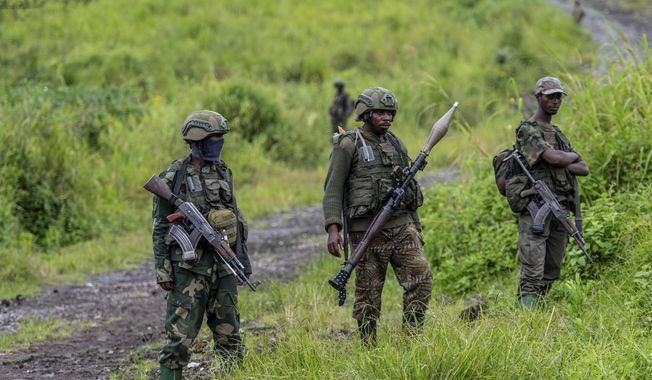 A M23 rebels stand with theirs weapons during a ceremony to mark the withdrawal from their positions in the town of Kibumba, in the eastern of Democratic Republic of Congo, on Dec. 23, 2022. The accounts are haunting. Abductions, torture, rapes. Scores of civilians including women and children have been killed by the M23 rebels in eastern Congo, according to a U.N. report expected to be published this week. (AP Photo/Moses Sawasawa, File)
