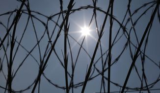 The sun shines through concertina wire on a fence at the Louisiana State Penitentiary in Angola, La., April 26, 2014. Louisiana&#39;s prison system routinely holds people beyond their legal release dates, the U.S. Department of Justice said Wednesday, Jan. 25, 2023, in a report concluding that the state has failed for years to develop solutions to “systemic overdetentions” that violate inmates&#39; rights and are financially costly to taxpayers. (AP Photo/Gerald Herbert, File)