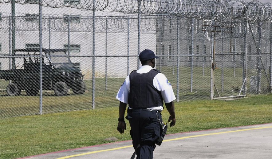 Prison staff work at Lee Correctional Institution, in Bishopville, S.C., April 10, 2019. Top state prosecutors are urging Congress to pass legislation allowing state prisons to jam the signals of cellphones smuggled to inmates behind bars. The 22 attorneys general say Wednesday in a letter to House Speaker Kevin McCarthy and Senate Majority Leader Chuck Schumer that the devices allow prisoners to plot violence and carry out crimes. (AP Photo/Meg Kinnard, File)
