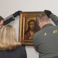Two people take down the diptych of Ecce Homo after the signing of the act of restitution of the diptych of the Dolorosa and Ecce Homo to Poland at the Museum of Pontevedra in Pontevedra, northwestern Spain, Wednesday, Jan. 25, 2023. A museum in northwest Spain has returned two 15th-century paintings to Polish officials after it was determined that they were looted by the forces of Nazi Germany during World War II. (Gustavo de la Paz/Europa Press via AP)