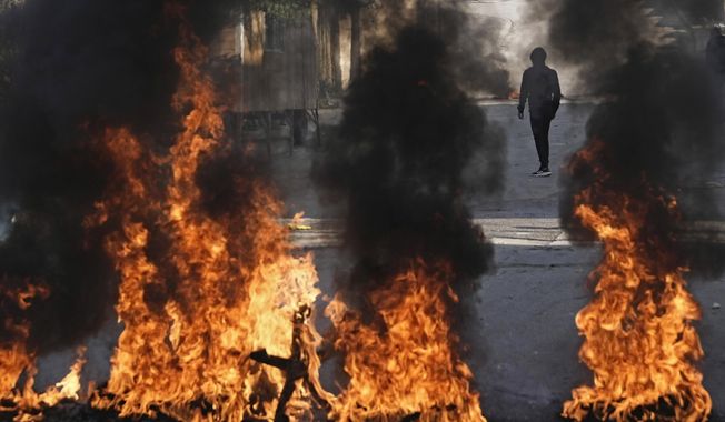 Palestinian demonstrators burn tires in a protest against a deadly Israeli army raid at Aida Refugee camp, in the West Bank city of Bethlehem, Thursday, Jan. 26, 2023. During the raid in the West Bank town of Jenin, Israeli forces killed at least nine Palestinians, including a 60-year-old woman, and wounded several others, Palestinian health officials said, in one of the deadliest days of fighting in years. The Israeli military said it was conducting an operation to arrest militants when a gun battle erupted. (AP Photo/Mahmoud Illean)