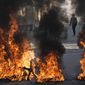 Palestinian demonstrators burn tires in a protest against a deadly Israeli army raid at Aida Refugee camp, in the West Bank city of Bethlehem, Thursday, Jan. 26, 2023. During the raid in the West Bank town of Jenin, Israeli forces killed at least nine Palestinians, including a 60-year-old woman, and wounded several others, Palestinian health officials said, in one of the deadliest days of fighting in years. The Israeli military said it was conducting an operation to arrest militants when a gun battle erupted. (AP Photo/Mahmoud Illean)
