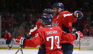 Washington Capitals left wing Alex Ovechkin, right, celebrates his goal against the Pittsburgh Penguins with defenseman Dmitry Orlov (9) and left wing Conor Sheary (73) during the first period of an NHL hockey game Thursday, Jan. 26, 2023, in Washington. (AP Photo/Nick Wass)