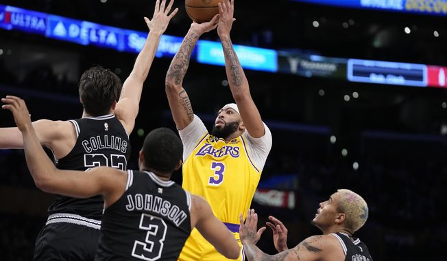 Los Angeles Lakers forward Anthony Davis, second from right, shoots as San Antonio Spurs forward Zach Collins, left, forward Keldon Johnson, second from right, and forward Jeremy Sochan defend during the first half of an NBA basketball game Wednesday, Jan. 25, 2023, in Los Angeles. (AP Photo/Mark J. Terrill)