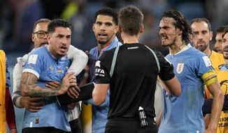 Uruguay&#39;s Edinson Cavani, right, argues with referee Daniel Siebert of Germany, at the end of a World Cup group H soccer match against Ghana at the Al Janoub Stadium in Al Wakrah, Qatar, on Dec. 2, 2022. FIFA banned Uruguay players Fernando Muslera and José María Giménez for four games each on Friday Jan. 27, 2023 for aggressively confronting match officials when the team was eliminated from the World Cup last month. Veterans Edinson Cavani and Diego Godín must also serve one-game bans when Uruguay next plays, FIFA said in announcing disciplinary verdicts. (AP Photo/Darko Vojinovic, File)