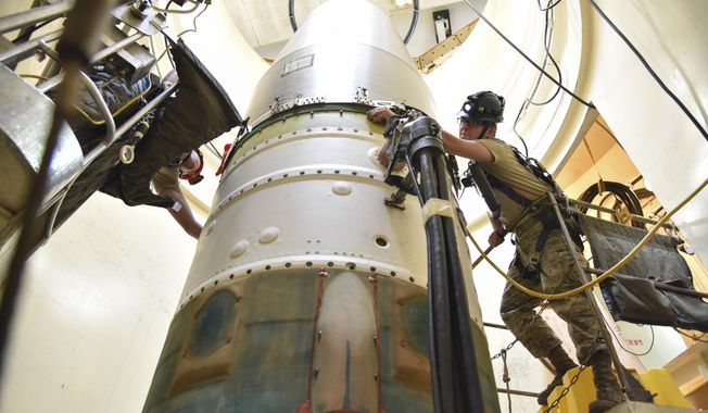 In this image provided by the U.S. Air Force, Airman 1st Class Jackson Ligon, left, and Senior Airman Jonathan Marinaccio, 341st Missile Maintenance Squadron technicians, connect a re-entry system to a spacer on an intercontinental ballistic missile during a Simulated Electronic Launch-Minuteman test Sept. 22, 2020, at a launch facility near Malmstrom Air Force Base in Great Falls, Mont. The top Air Force officer in charge of the nation&#x27;s air and ground-launched nuclear missiles has requested an official investigation into the number of officers who are reporting the same type of blood cancer after serving at Malmstrom Air Force Base. (Senior Airman Daniel Brosam/U.S. Air Force via AP)