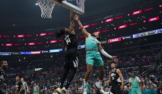 Los Angeles Clippers guard Terance Mann (14) blocks a shot by San Antonio Spurs guard Tre Jones (33) during the first half of an NBA basketball game in Los Angeles, Thursday, Jan. 26, 2023. (AP Photo/Ashley Landis)