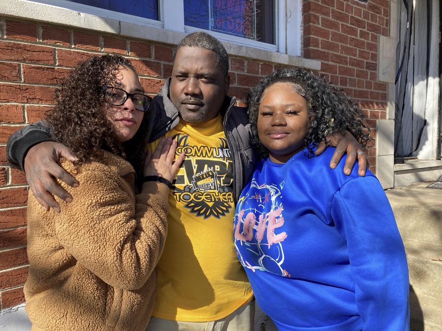 McKynzi Douglas, right, stands with her parents, John and Janay Douglas, outside their home on Thursday, Jan. 26, 2023, in St. Louis, Mo. McKynzi and other students of Central Visual and Performing Arts High School in St. Louis recently returned to school for the first time since fleeing from a shooting last October that killed two and wounded seven. (AP Photo/Jim Salter)