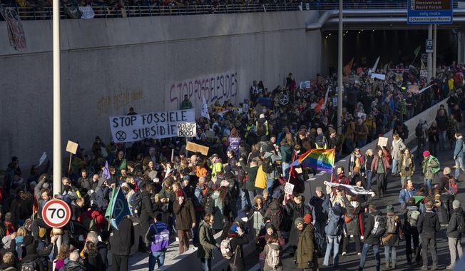 Extinction Rebellion activists and sympathisers block a busy road in The Hague, Netherlands, Saturday, Jan. 28, 2023. Earlier this week seven Extinction Rebellion activists were detained by authorities for sedition linked to the protest. (AP Photo/Peter Dejong)