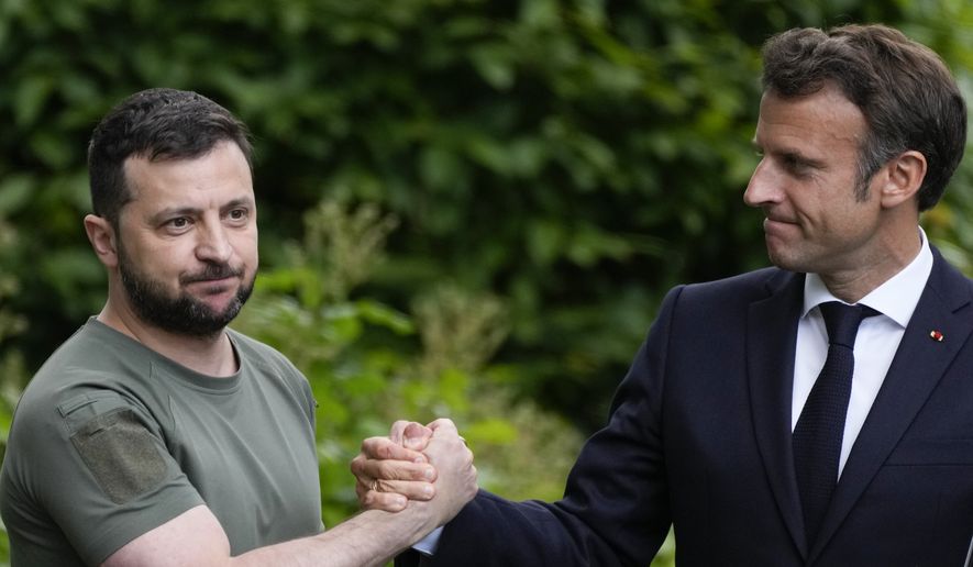 Ukraine President Volodymyr Zelenskyy, left, and France's President Emmanuel Macron shake hands at the end of a press conference at the Mariyinsky Palace in Kyiv, Ukraine, Thursday, June 16, 2022. (AP Photo/Natacha Pisarenko, File)