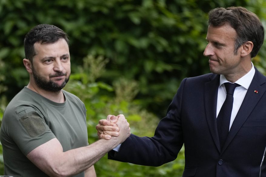 Ukraine President Volodymyr Zelenskyy, left, and France's President Emmanuel Macron shake hands at the end of a press conference at the Mariyinsky Palace in Kyiv, Ukraine, Thursday, June 16, 2022. (AP Photo/Natacha Pisarenko, File)