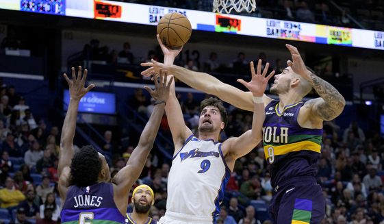 Washington Wizards forward Deni Avdija (9) shoots against New Orleans Pelicans center Willy Hernangomez (9), right, and forward Herbert Jones (5) in the first half of an NBA basketball game in New Orleans, Saturday, Jan. 28, 2023. (AP Photo/Matthew Hinton)