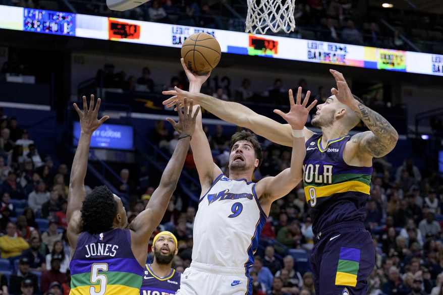 Washington Wizards forward Deni Avdija (9) shoots against New Orleans Pelicans center Willy Hernangomez (9), right, and forward Herbert Jones (5) in the first half of an NBA basketball game in New Orleans, Saturday, Jan. 28, 2023. (AP Photo/Matthew Hinton)