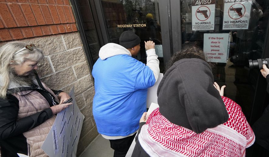 A group of demonstrators knock on a locked entrance as they protest outside a police precinct in response to the death of Tyre Nichols, who died after being beaten by Memphis police officers, in Memphis, Tenn., Sunday, Jan. 29, 2023. (AP Photo/Gerald Herbert)