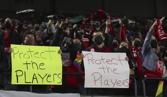 Portland Thorns fans hold signs during the first half of the team&#39;s NWSL soccer match against the Houston Dash in Portland, Ore., Oct. 6, 2021. On Monday, Jan. 30, 2023, U.S. Soccer introduced a Safe Soccer program that will require comprehensive vetting of individuals involved in the sport as the federation continues to address its investigation into coach misconduct in the National Women&#39;s Soccer League. (AP Photo/Steve Dipaola, File) **FILE**