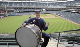 In this April 27, 2011, photo, Cleveland Indians fan John Adams poses in his usual centerfield bleacher seat with his ever-present bass drum before a baseball game between the Indians and the Kansas City Royals in Cleveland. Adams, who pounded a drum while sitting in Cleveland&#39;s outfield bleachers during baseball games for five decades, has died. He was 71. The Guardians announced his passing on Monday, Jan. 30, 2023. (AP Photo/Amy Sancetta) **FILE**