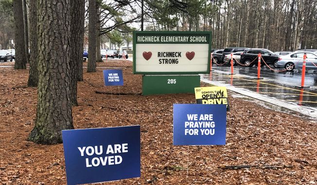 Signs stand outside Richneck Elementary School in Newport News, Va., on Jan. 25, 2023. The school is set to reopen Monday, Jan. 30, more than three weeks after a Jan. 6 shooting. Police have said a boy brought a 9mm handgun to school and intentionally shot his teacher, Abby Zwerner, as she was teaching her first-grade class. (AP Photo/Denise Lavoie, File)