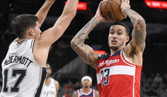 Washington Wizards&#x27; Kyle Kuzma (33) looks to pass the ball as he is defended by San Antonio Spurs&#x27; Doug McDermott during the second half of an NBA basketball game, Monday, Jan. 30, 2023, in San Antonio. (AP Photo/Darren Abate)