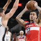 Washington Wizards&#39; Kyle Kuzma (33) looks to pass the ball as he is defended by San Antonio Spurs&#39; Doug McDermott during the second half of an NBA basketball game, Monday, Jan. 30, 2023, in San Antonio. (AP Photo/Darren Abate)