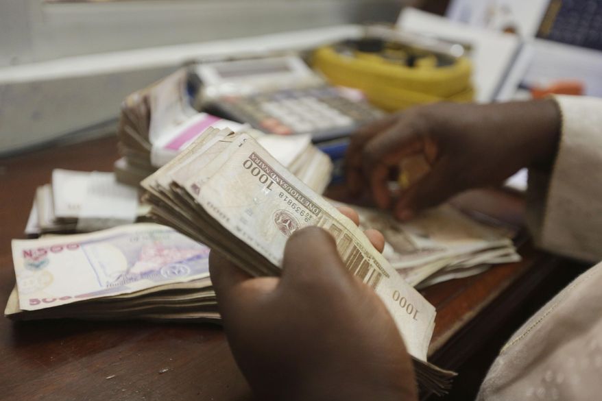 A money changer counts Nigerian naira currency at a bureau de change, in Lagos Nigeria, Oct. 20, 2015. Nigeria&#x27;s push to replace the local currency notes with newly designed ones is creating an economic crisis, experts warned Monday, Jan. 30, 2023 with the limited cash in circulation hurting many people and businesses across the West African nation. (AP Photo/Sunday Alamba, File)