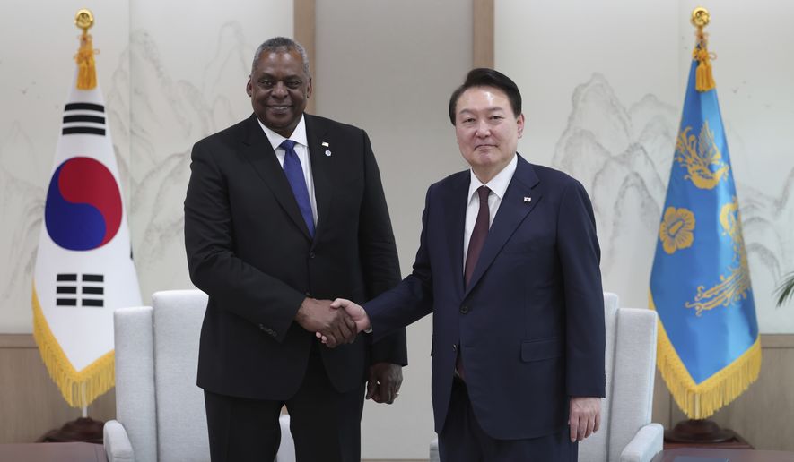 South Korean President Yoon Suk Yeol, right, shakes hands with U.S. Secretary of Defense Lloyd Austin during a meeting at the presidential office in Seoul, South Korea, Tuesday, Jan. 31, 2023. Austin on Tuesday said the United States will increase its deployment of advanced weapons such as fighter jets and bombers to the Korean Peninsula as it strengthens joint training and operational planning with South Korea in response to a growing North Korean nuclear threat. (South Korea Presidential Office/Yonhap via AP)