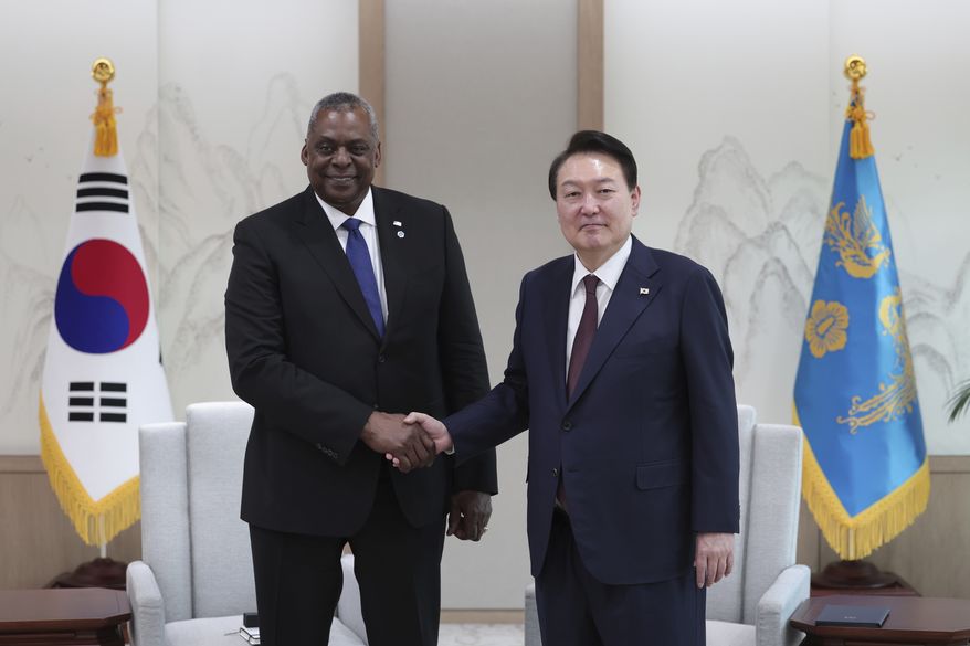 South Korean President Yoon Suk Yeol, right, shakes hands with U.S. Secretary of Defense Lloyd Austin during a meeting at the presidential office in Seoul, South Korea, Tuesday, Jan. 31, 2023. Austin on Tuesday said the United States will increase its deployment of advanced weapons such as fighter jets and bombers to the Korean Peninsula as it strengthens joint training and operational planning with South Korea in response to a growing North Korean nuclear threat. (South Korea Presidential Office/Yonhap via AP)
