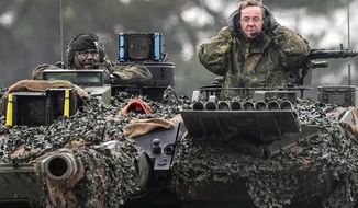 German Defense Minister Boris Pistorius, right, sits on a Leopard 2 tank at the Bundeswehr tank battalion 203 at the Field Marshal Rommel Barracks in Augustdorf, Germany, Wednesday, Feb. 1, 2023. After the government&#39;s decision to deliver fourteen Leopard 2 tanks to Ukraine, the capabilities of the Leopard 2A6 main battle tank are shown at a presentation in Augustdorf. (AP Photo/Martin Meissner)