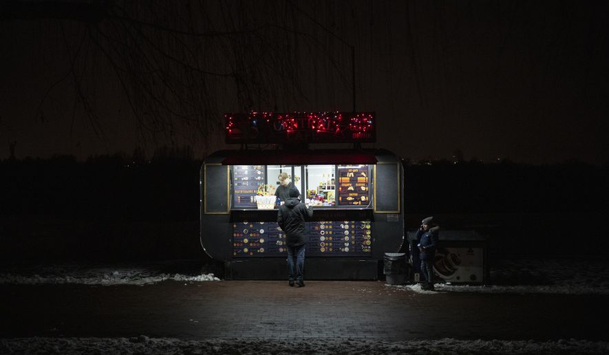 A man buys snacks at a kiosk in Kyiv, Ukraine, Tuesday, Jan. 31, 2023. (AP Photo/Daniel Cole)