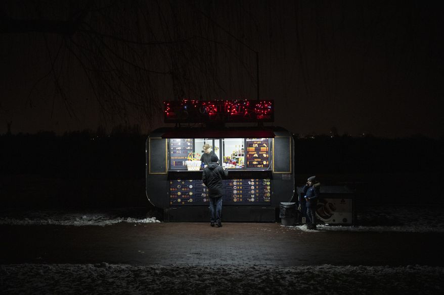 A man buys snacks at a kiosk in Kyiv, Ukraine, Tuesday, Jan. 31, 2023. (AP Photo/Daniel Cole)