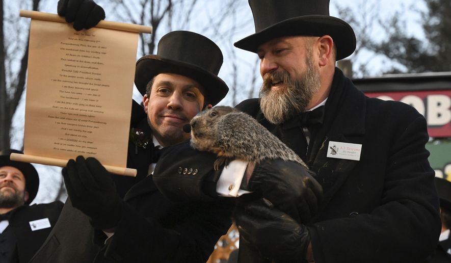 Groundhog Club handler A.J. Dereume holds Punxsutawney Phil, the weather prognosticating groundhog, while Vice President Dan McGinley reads the scroll during the 137th celebration of Groundhog Day on Gobbler&#x27;s Knob in Punxsutawney, Pa., Thursday, Feb. 2, 2023. Phil&#x27;s handlers said that the groundhog has forecast six more weeks of winter. (AP Photo/Barry Reeger)