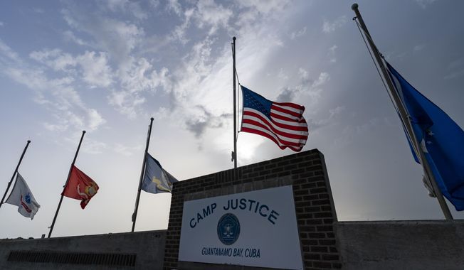 In this photo reviewed by U.S. military officials, flags fly at half-staff at Camp Justice, Aug. 29, 2021, in Guantanamo Bay Naval Base, Cuba. Majid Khan, the onetime courier for al-Qaida is a free man after serving more than 16 years at Guantanamo, and surviving torture at notorious CIA &quot;black sites.&quot; The Pentagon announced the release of Pakistan citizen Khan on Thursday, Feb. 2, 2023. Khan is now in Belize, after that nation reached agreement with the Biden administration to take him. (AP Photo/Alex Brandon, File)