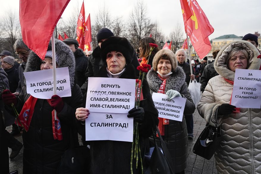 Communist supporters hold placards calling for renaming Volgograd to Stalingrad as it was previously called, in Volgograd, as they lineup at the Tomb Stalingrad during a wreath-laying ceremony at the Tomb of the Unknown Soldier, near the Kremlin Wall as they attend a commemoration marking the 80th anniversary of the Soviet victory in the battle of Stalingrad in Moscow, Russia, Thursday, Feb. 2, 2023. The battle of Stalingrad turned the tide of World War II and is regarded as the bloodiest battle in history, with the death toll for soldiers and civilians estimated at about 2 millions. (AP Photo/Alexander Zemlianichenko)