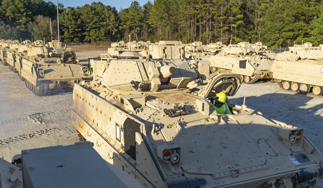 In this image provided by U.S. Transportation Command, a stevedore sits in a Bradley Fighting Vehicle before loading it onto the ARC Wallenius Wilhemsen Jan. 25, 2023, at the Transportation Core Dock in North Charleston, S.C. After months of agonizing, the U.S has agreed to send longer-range bombs to Ukraine as it prepares to launch a spring offensive to retake territory Russia captured last year, U.S. officials said Thursday, confirming that the new weapons will have roughly double the range of any other offensive weapon provided by America. (Oz Suguitan/U.S. Transportation Command via AP) **FILE**