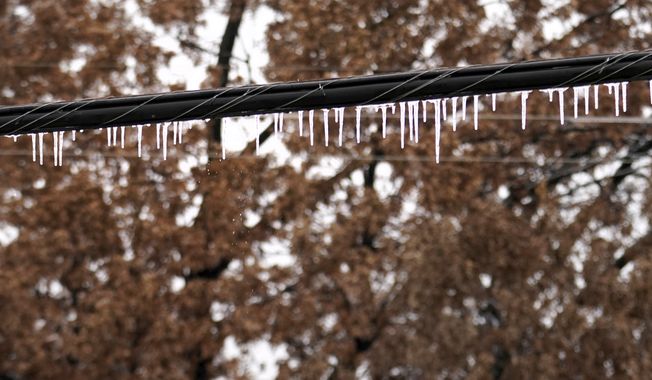 Icicles coat and hang off an electrical line after a few days of sleet and snow, Thursday, Feb. 2, 2023, in Richardson, Texas. (AP Photo/Tony Gutierrez)