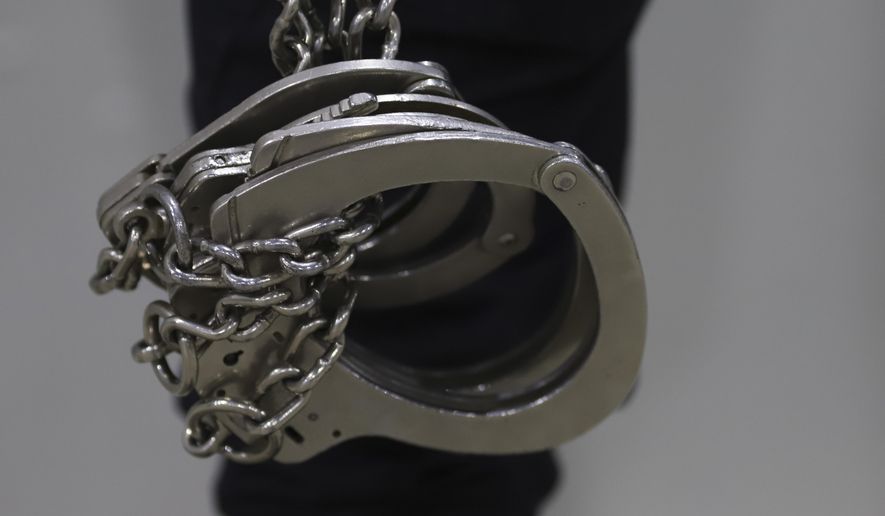 A prison guard holds handcuffs during a media tour of The Terrorism Confinement Center in Tecoluca, El Salvador, Thursday, Feb. 2, 2023. The &quot;mega-prison&quot; still under construction has a maximum capacity of 40,000 and is intended to imprison gang members, according to the government. (AP Photo/Salvador Melendez)