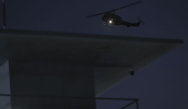 An Air Force helicopter flies over the Terrorism Confinement Center during a media tour in Tecoluca, El Salvador, late Thursday, Feb. 2, 2023. The &quot;mega-prison&quot; still under construction has a maximum capacity of 40,000 and is intended to imprison gang members, according to the government. (AP Photo/Salvador Melendez)
