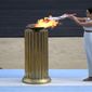 Greek actress Xanthi Georgiou, playing the role of High Priestess, lights the torch with the flame during the Olympic flame handover ceremony at Panathinean stadium in Athens, Greece, Tuesday, Oct. 19, 2021. Instead of arriving overland, the symbolic flame alighting the Paris 2024 Games will take to the seas from its birthplace in Greece, arriving aboard a three-masted tall ship in the French port of Marseille. Paris 2024 organizers announced the flame&#39;s journey Friday Feb.3, 2023 at City Hall in Marseille, a former Greek colony founded 2,600 years ago. (AP Photo/Petros Giannakouris, File)