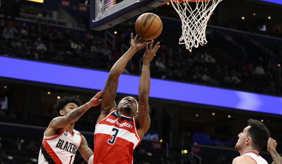 Washington Wizards guard Bradley Beal (3) goes to the basket past Portland Trail Blazers guard Anfernee Simons (1) and forward Drew Eubanks, right, during the first half of an NBA basketball game, Friday, Feb. 3, 2023, in Washington. (AP Photo/Nick Wass)